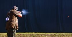 Flintenschütze beschießt Tonscheibe